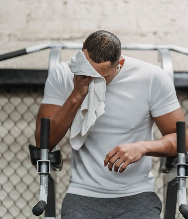 Man performing a strength training exercise in a modern gym.